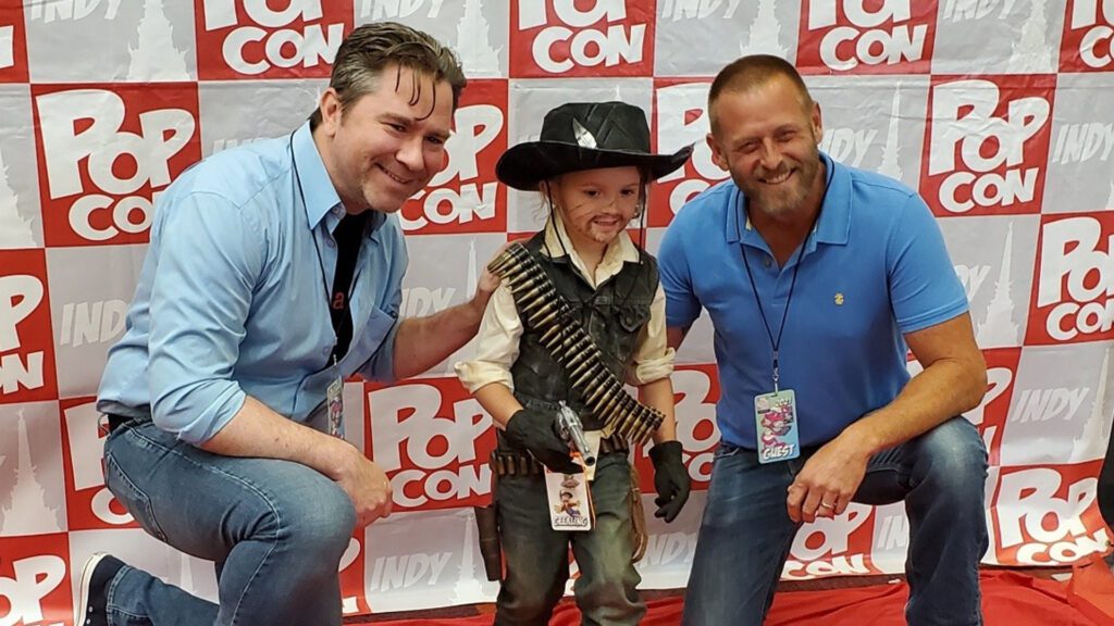 Rob Weithoff and Roger Clark taking pictures with fans at PopCon